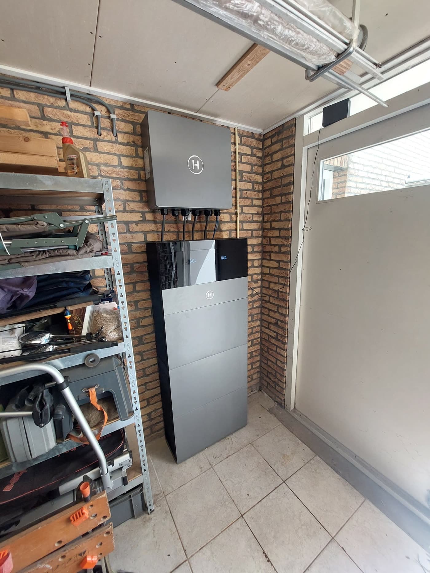 Hoymiles-thuisbatterij in de hoek van een garage, van opzij gezien