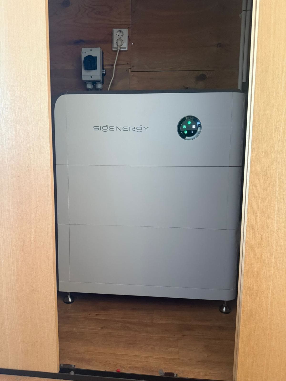 SigenStor-thuisbatterij in een berging naast opslagkasten
